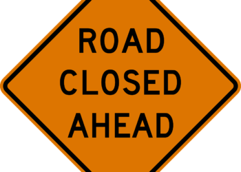 orange and black road closed ahead sign